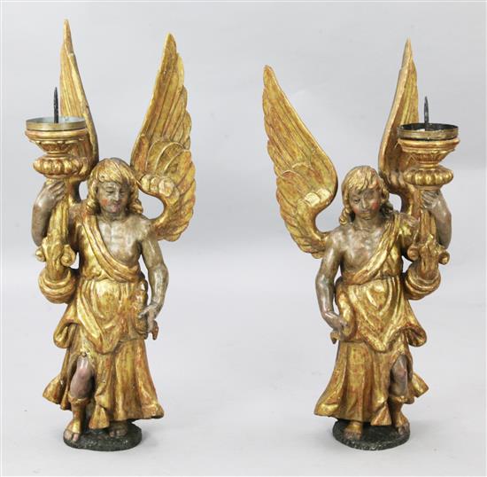 A pair of 17th century style painted and giltwood angel altar sticks, H.3ft